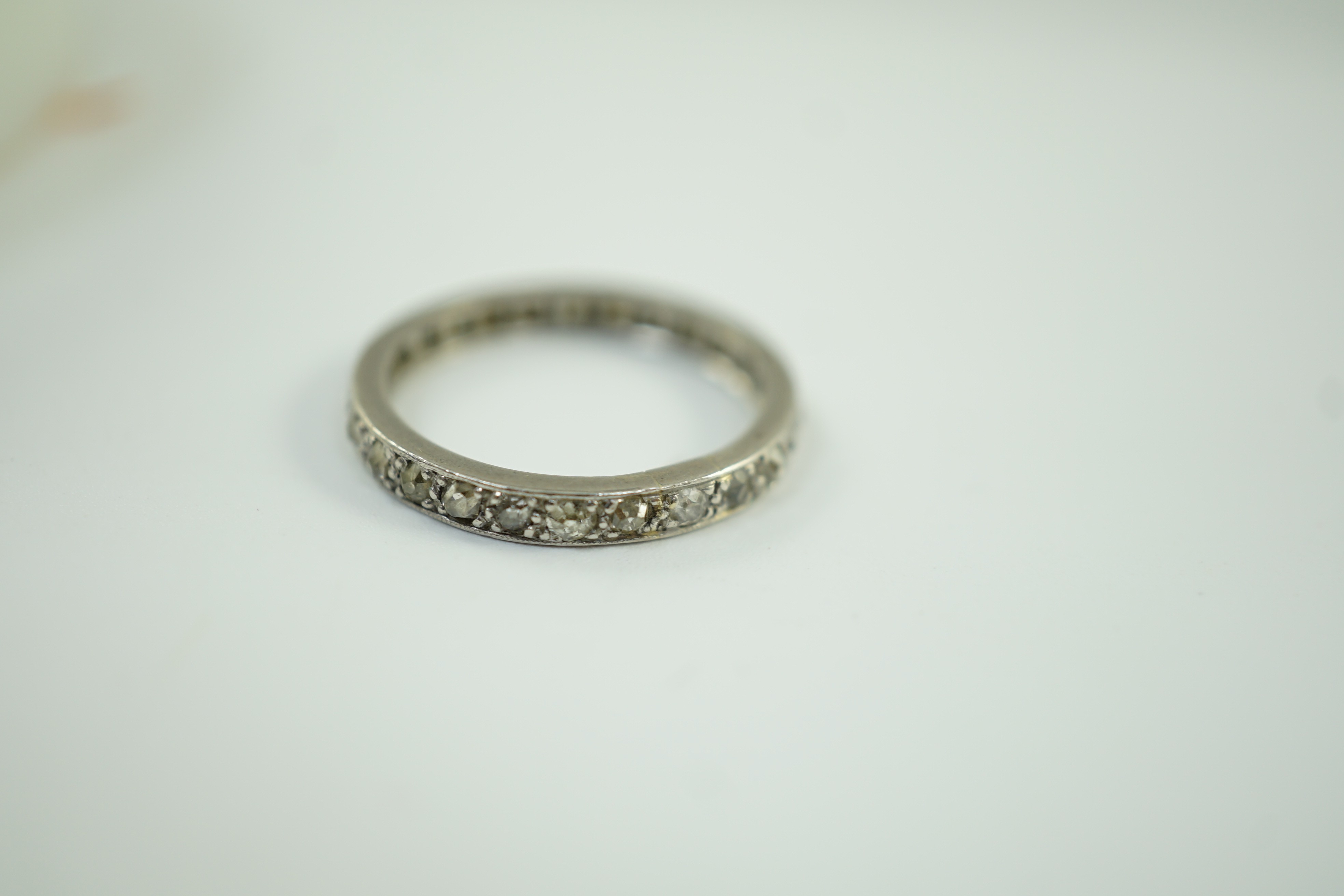 A white metal and diamond chip set full eternity ring, size L, gross weight 2.7 grams.